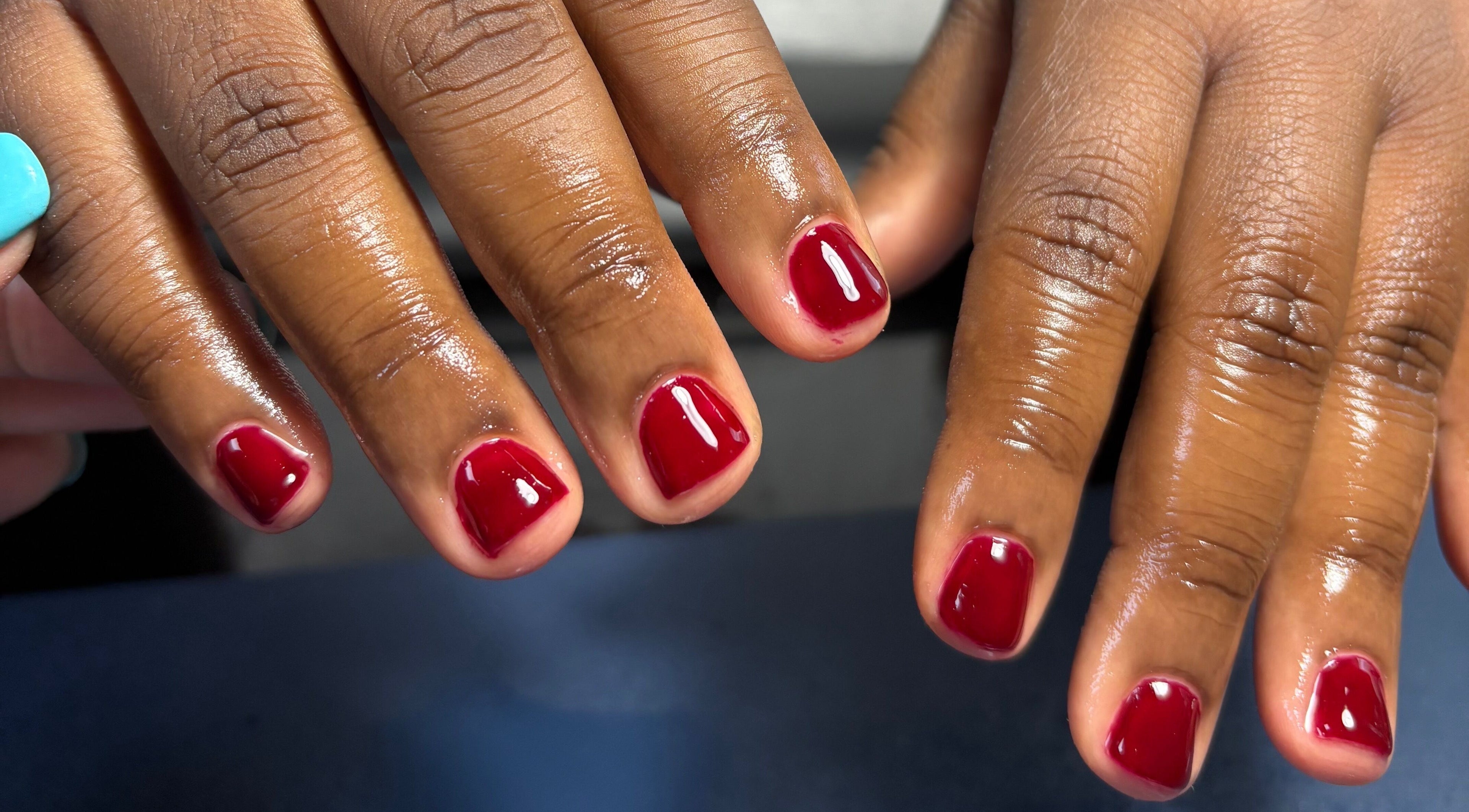 Red manicured nails at Tiffani Blu Studios, Atlanta, Georgia, US, showcasing expert nail care.