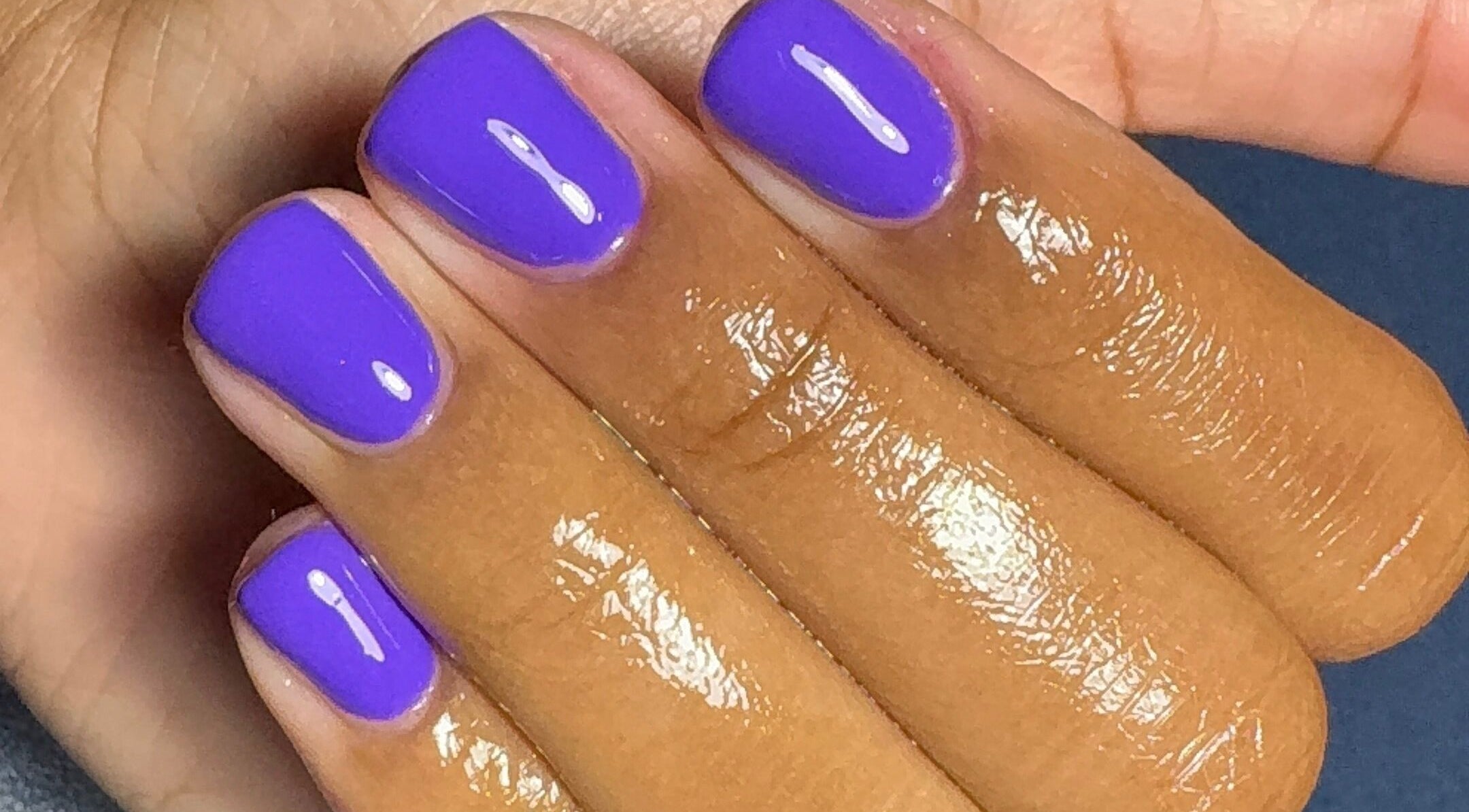 Bright violet nails manicure at Tiffani Blu Studios, Atlanta, Georgia, US, showcasing glossy finish.