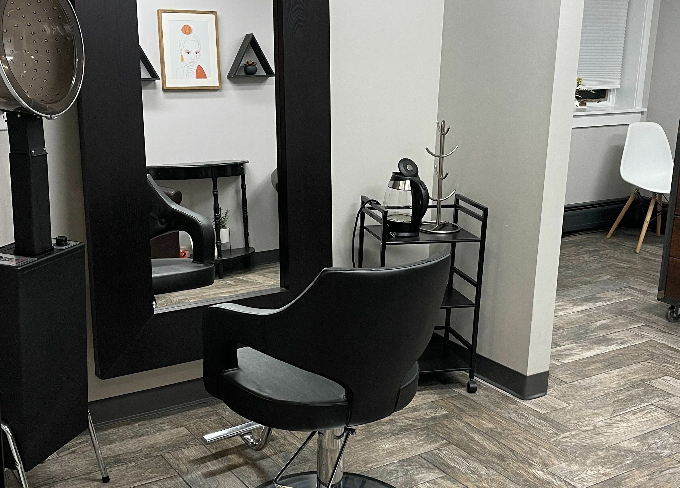 Modern salon interior at 66B Salon Meg B and Alicia C, Easthampton, Massachusetts, US, with sleek black furnishings.