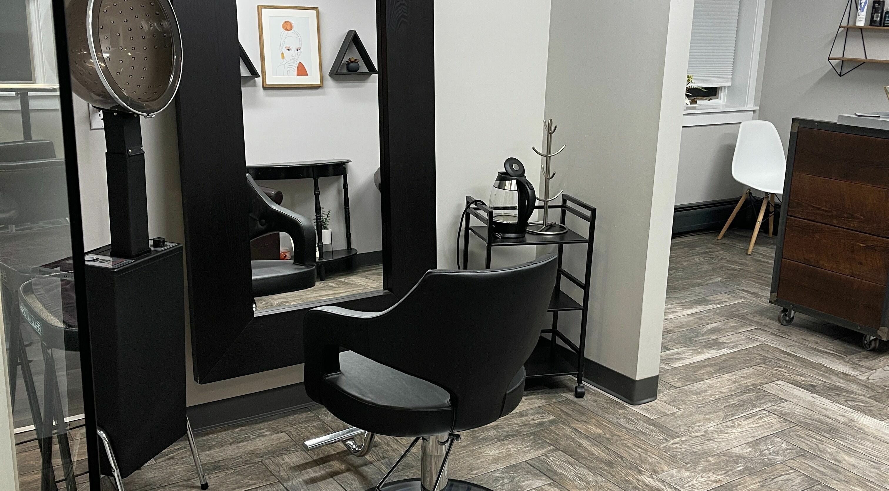 Modern salon interior at 66B Salon Meg B and Alicia C, Easthampton, Massachusetts, US, with sleek black furnishings.