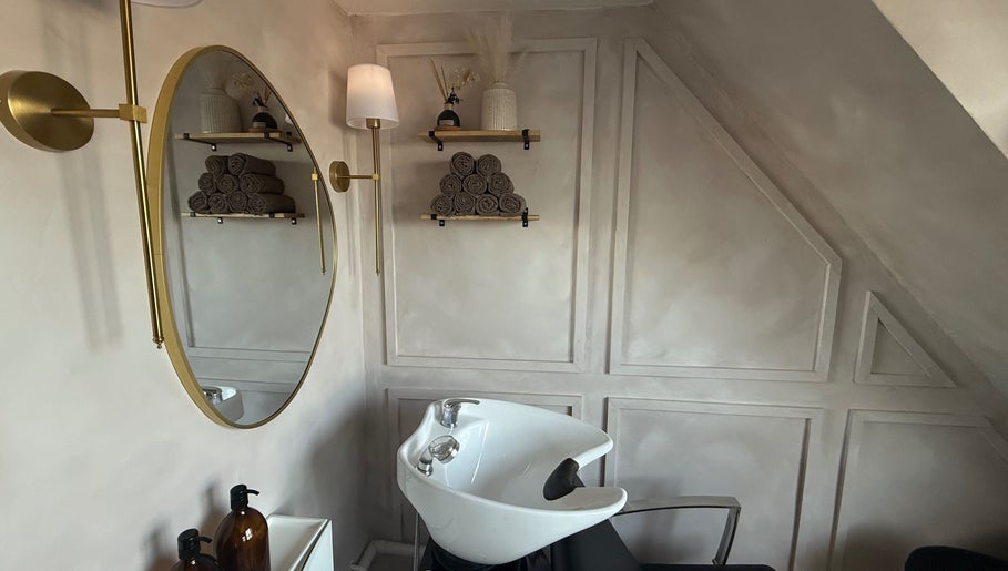Chic hair washing station at House of RC Hair, Garforth, England, GB, featuring a stylish mirror and shelving.