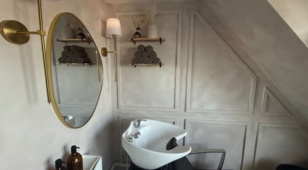 Chic hair washing station at House of RC Hair, Garforth, England, GB, featuring a stylish mirror and shelving.