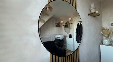 Elegant salon interior with round mirror at House of RC Hair, Garforth, England, GB.