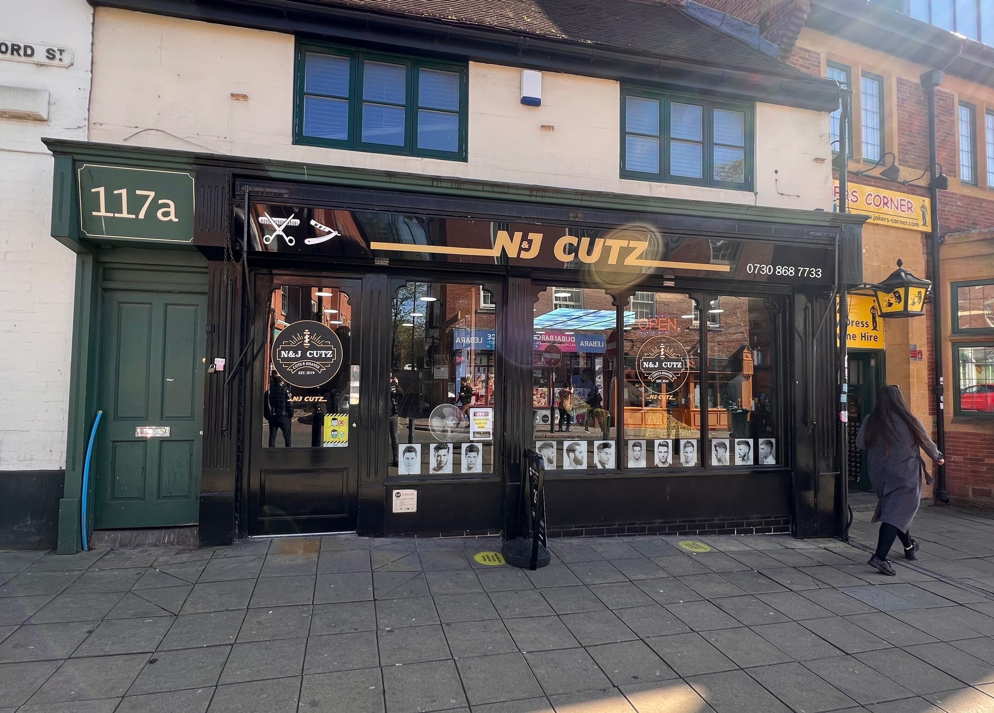 Front view of N & J Cutz salon located in Coventry, England, GB on a sunny day with clear signage.