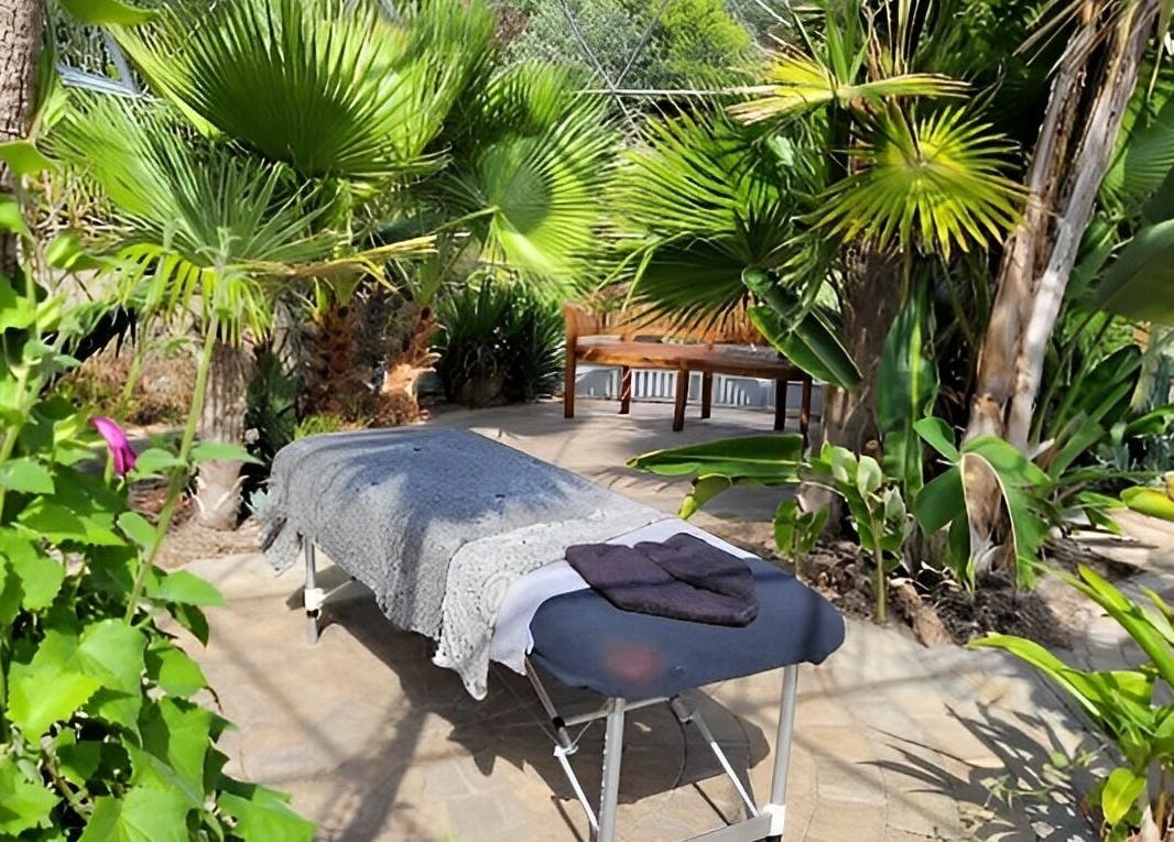 Relaxing massage table at Bethan Owen Complementary Healthcare, Cardiff Bay, Wales, GB surrounded by lush greenery.
