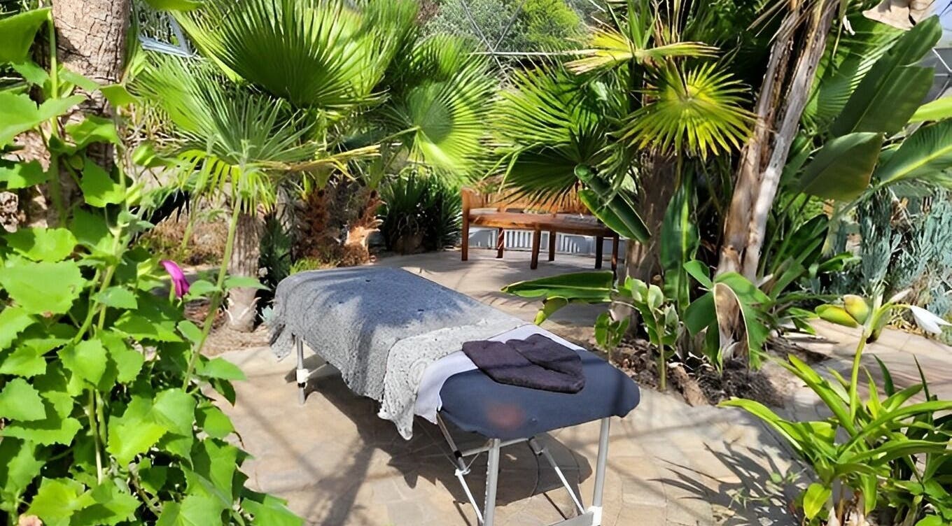 Relaxing massage table at Bethan Owen Complementary Healthcare, Cardiff Bay, Wales, GB surrounded by lush greenery.