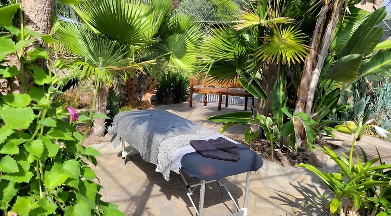 Relaxing massage table at Bethan Owen Complementary Healthcare, Cardiff Bay, Wales, GB surrounded by lush greenery.