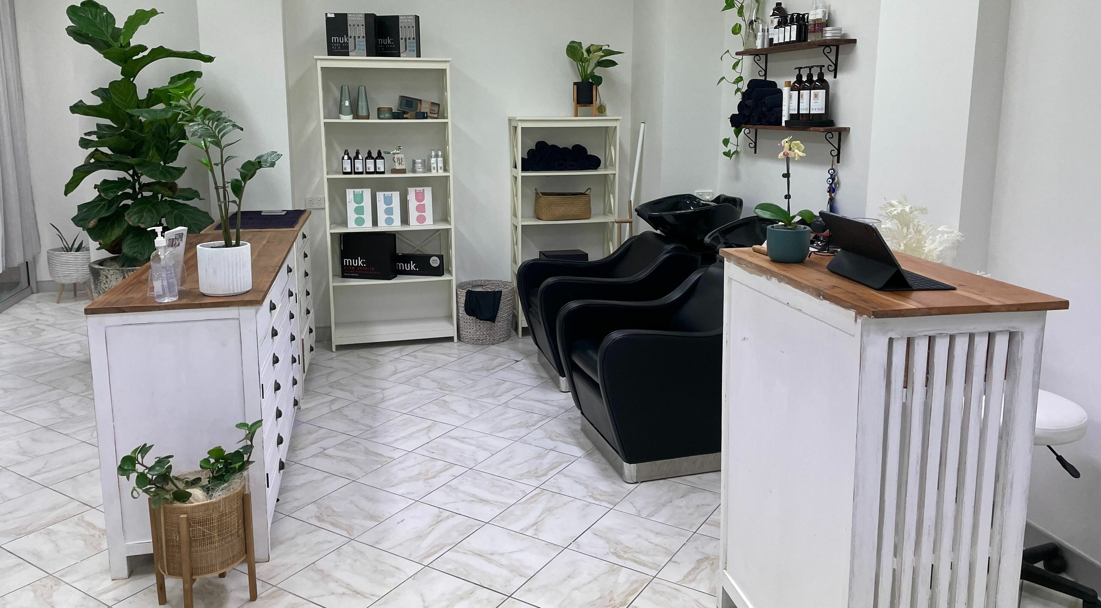 Stylish salon interior of Jacobs Hair Co, Gympie, Queensland, AU with modern chairs and lush plants.