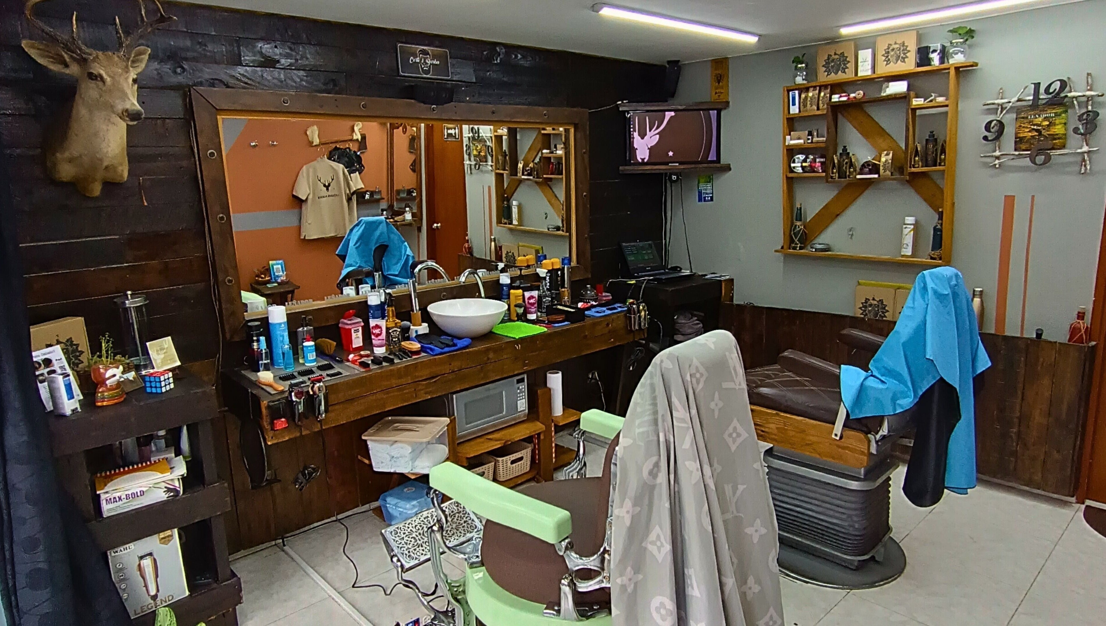Interior rústico de Leñador Barber en MANIZALES, Caldas, CO, mostrando sillas y productos estilísticos.