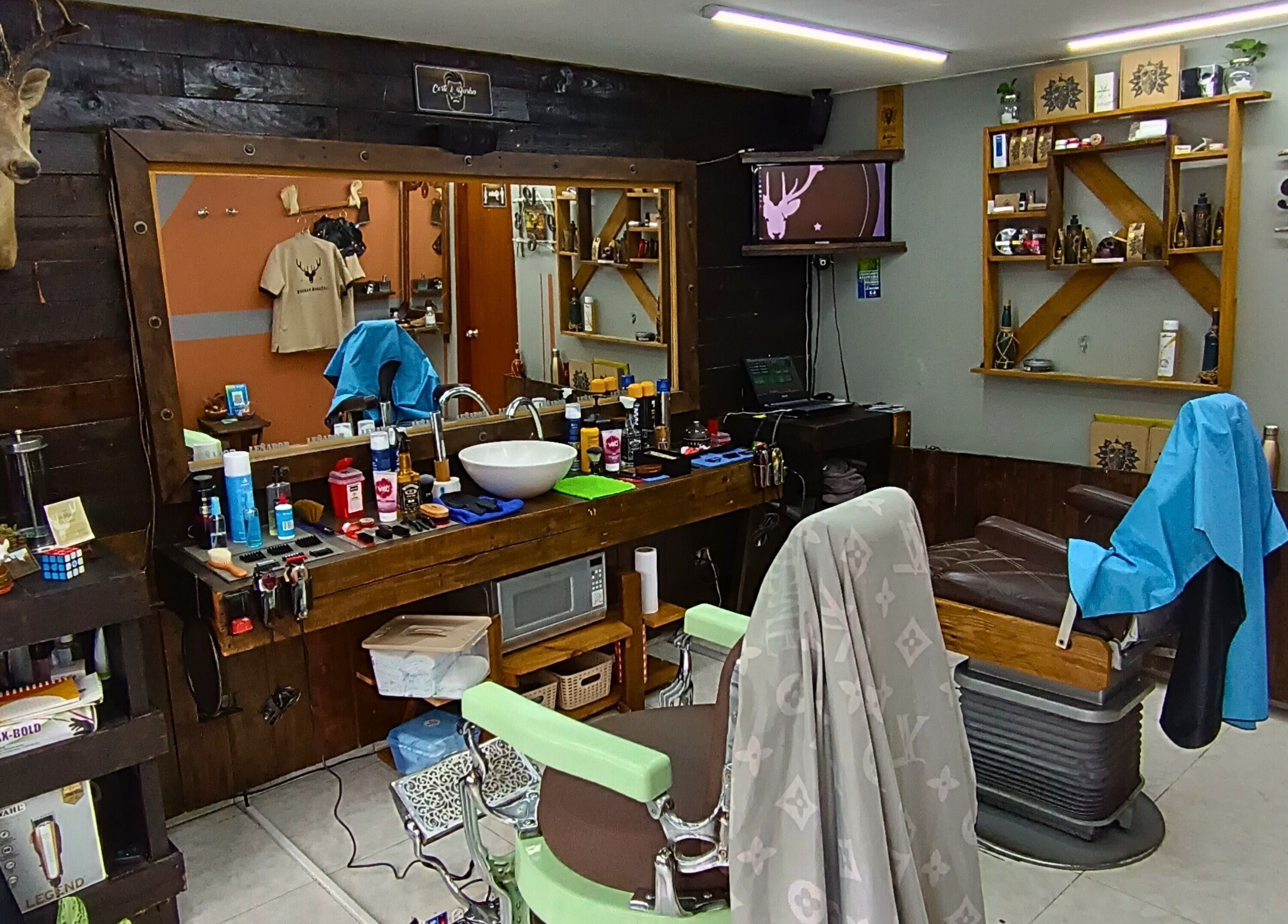 Interior rústico de Leñador Barber en MANIZALES, Caldas, CO, mostrando sillas y productos estilísticos.
