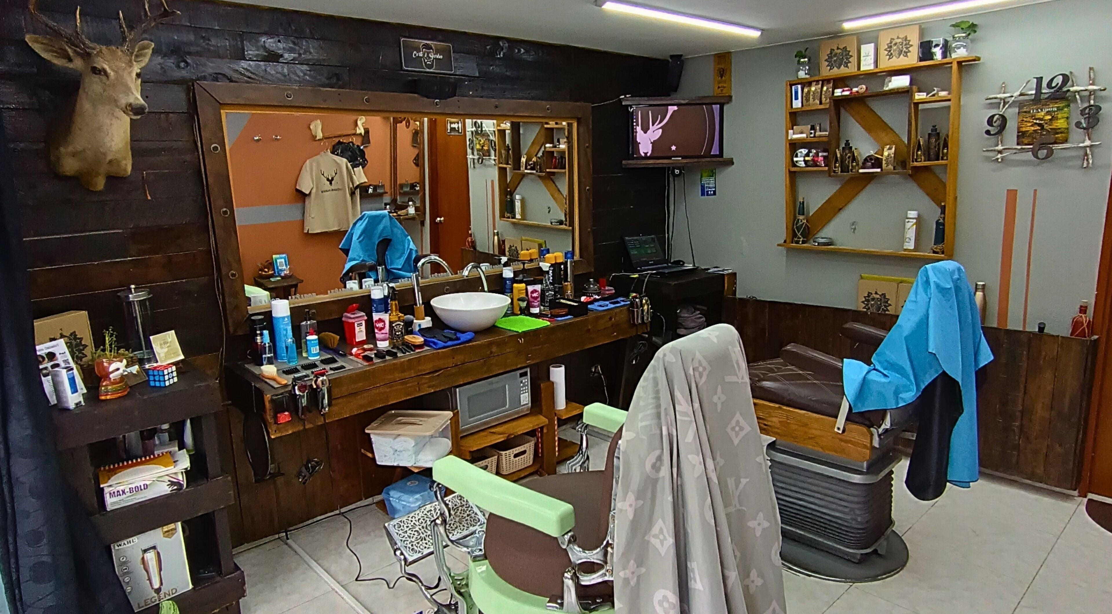 Interior rústico de Leñador Barber en MANIZALES, Caldas, CO, mostrando sillas y productos estilísticos.