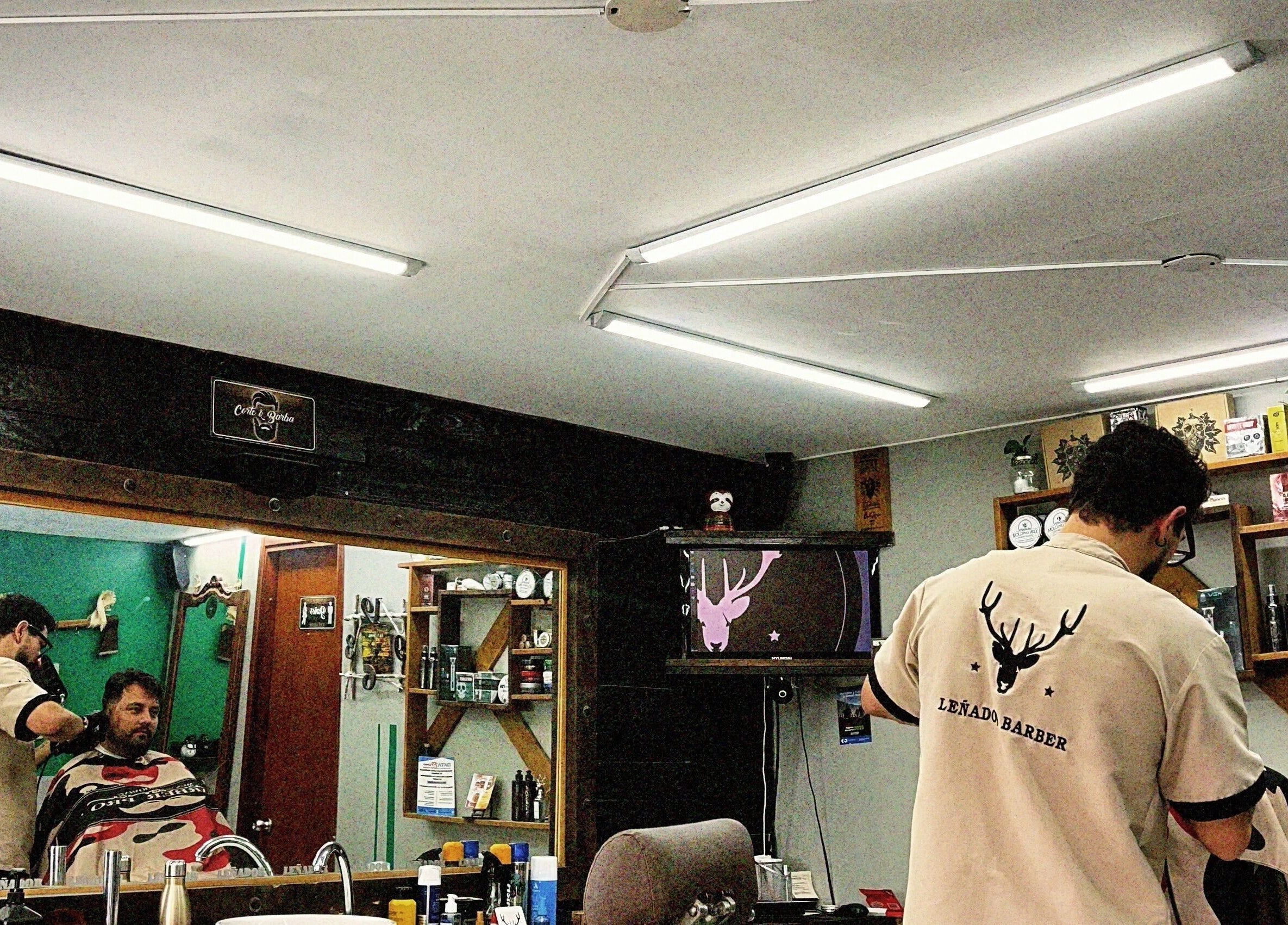 Interior de Leñador Barber en MANIZALES, Caldas, CO. Cliente recibiendo un corte de cabello en ambiente cálido.