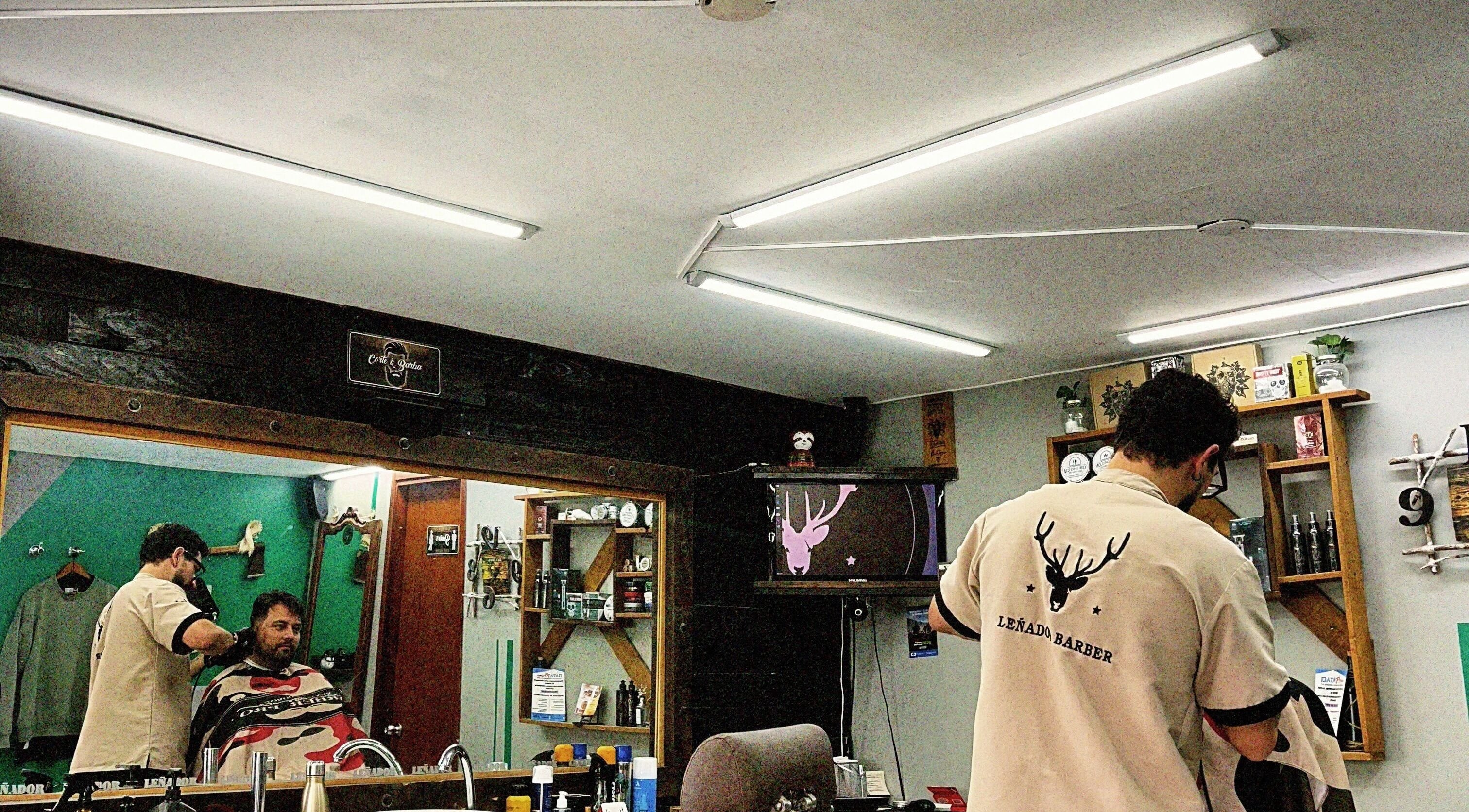 Interior de Leñador Barber en MANIZALES, Caldas, CO. Cliente recibiendo un corte de cabello en ambiente cálido.