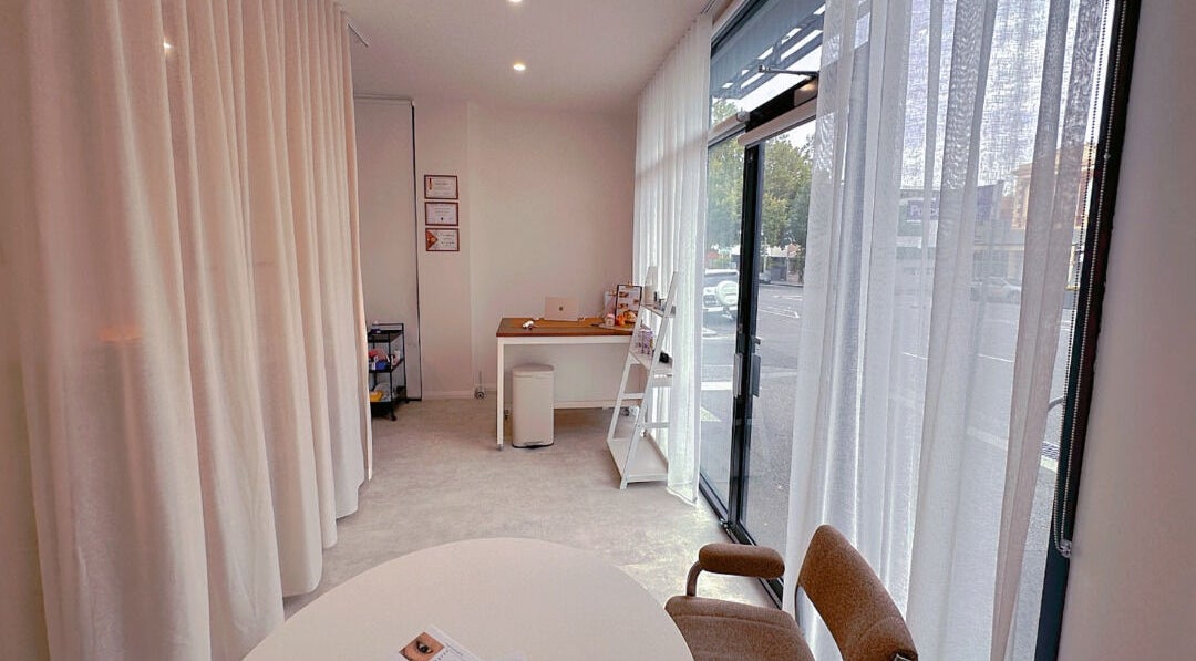 Bright, airy interior of Daylight Beauty in North Melbourne, Victoria, AU with modern decor and soft curtains.