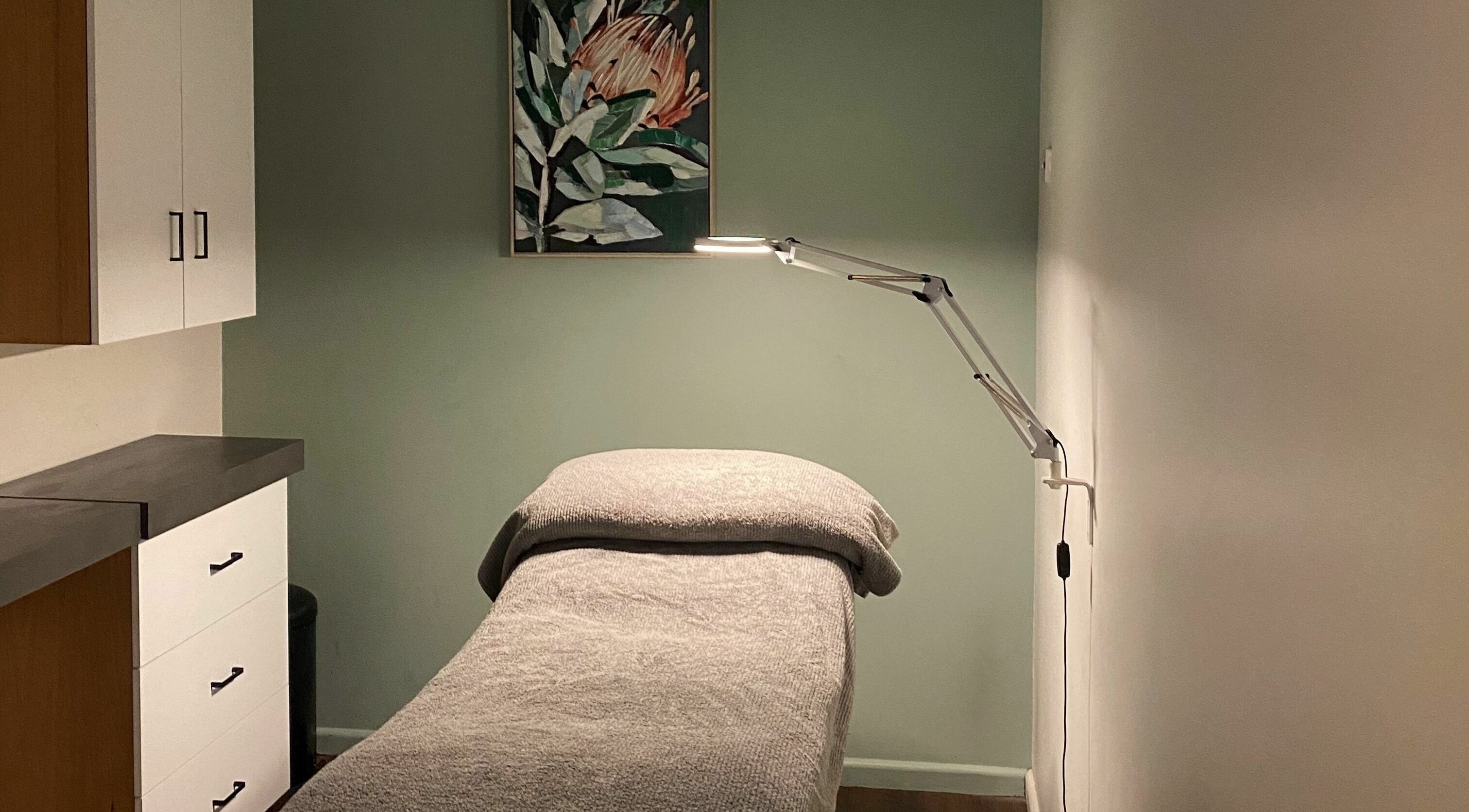 Relaxing massage room at Purebody, Launceston, Tasmania, AU with cozy bed and ambient lighting.