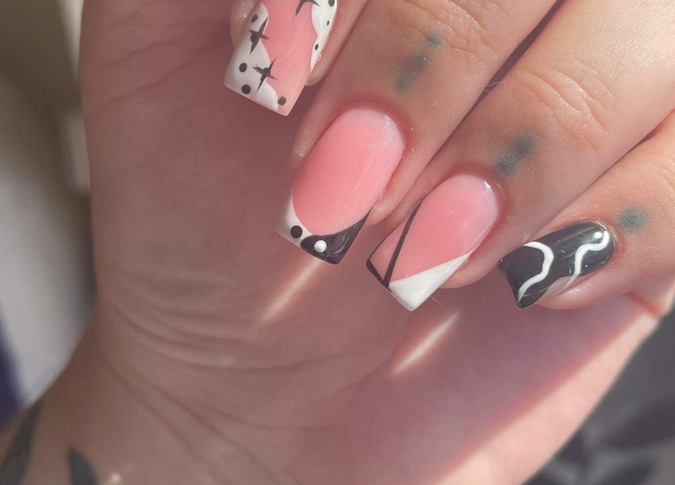 Elegant nail art at Beauty Lounge, Bargoed, Wales, GB, featuring black, pink, and white designs.