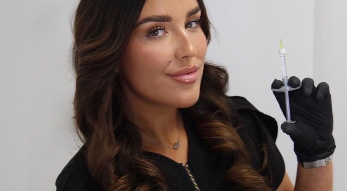 Professional at LJT Aesthetics in Herne Bay, England, GB, holding a syringe for aesthetic treatment.