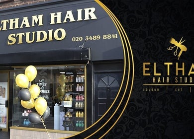 Eltham Hair Studio entrance in London, England, GB, with stylish black and gold design and decorative balloons.