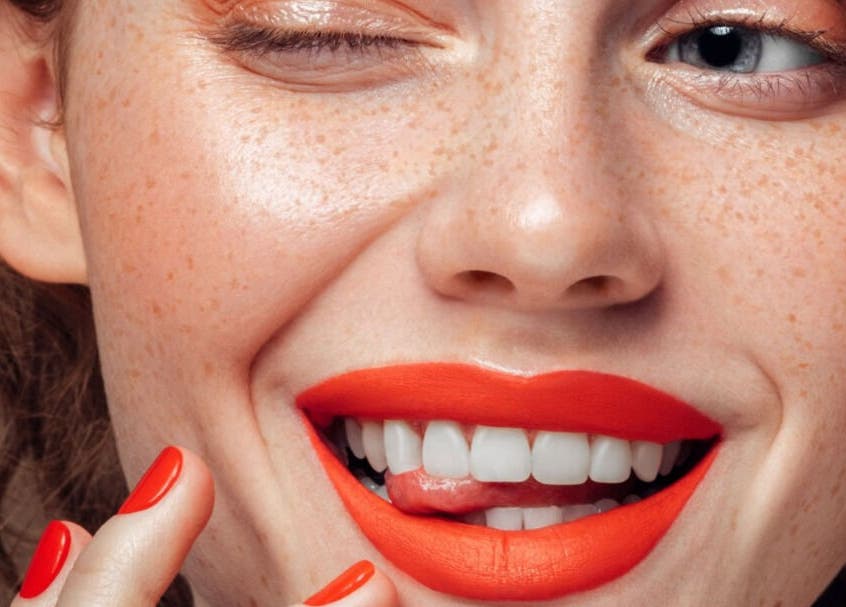 Modelo con labios rojos y uñas combinadas en Clínica Florencia, Concepción, Bío Bío, CL.