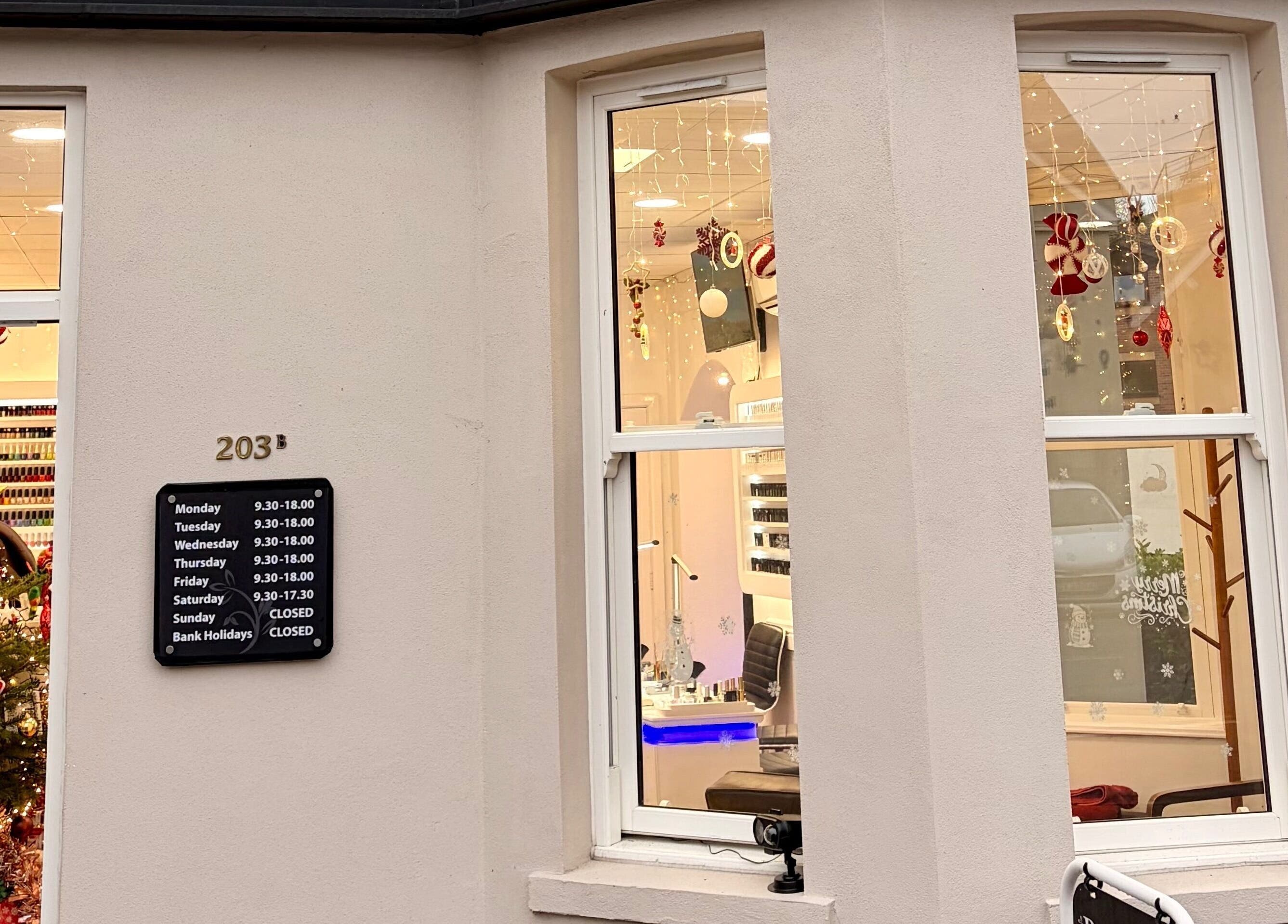 Exterior view of Broadstone Nails and Spa, Poole, England, GB, adorned with festive decor and holiday signage.