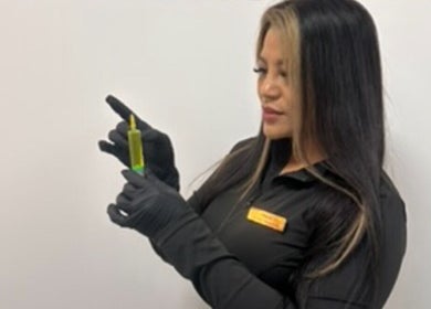 Beauty professional with serum at Mitch Aesthetics London, Uxbridge, England, GB.
