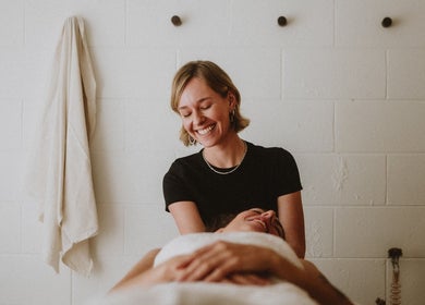 Massage therapy at Nurture in Byron Bay, New South Wales, AU. A therapist smiles while providing a calming treatment.