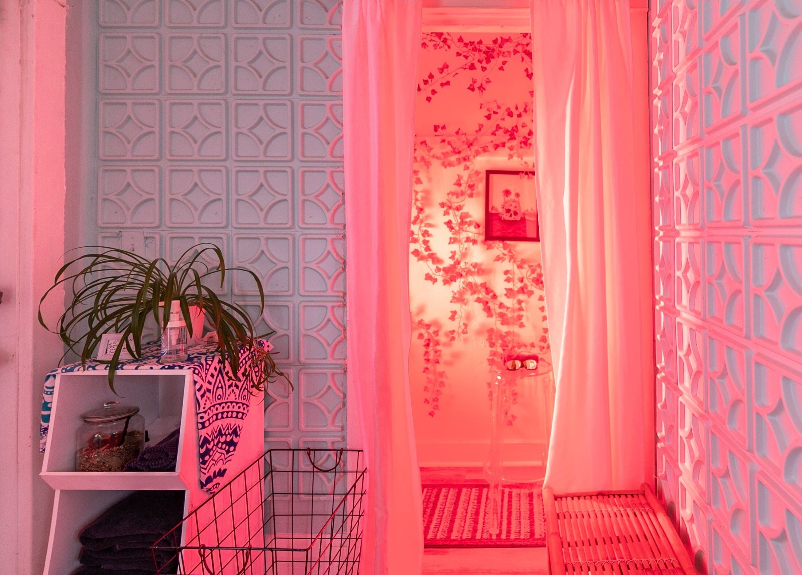 Cozy pink-lit wellness space at Middletown in Middletown, Rhode Island, US, with decorative walls and a plant.