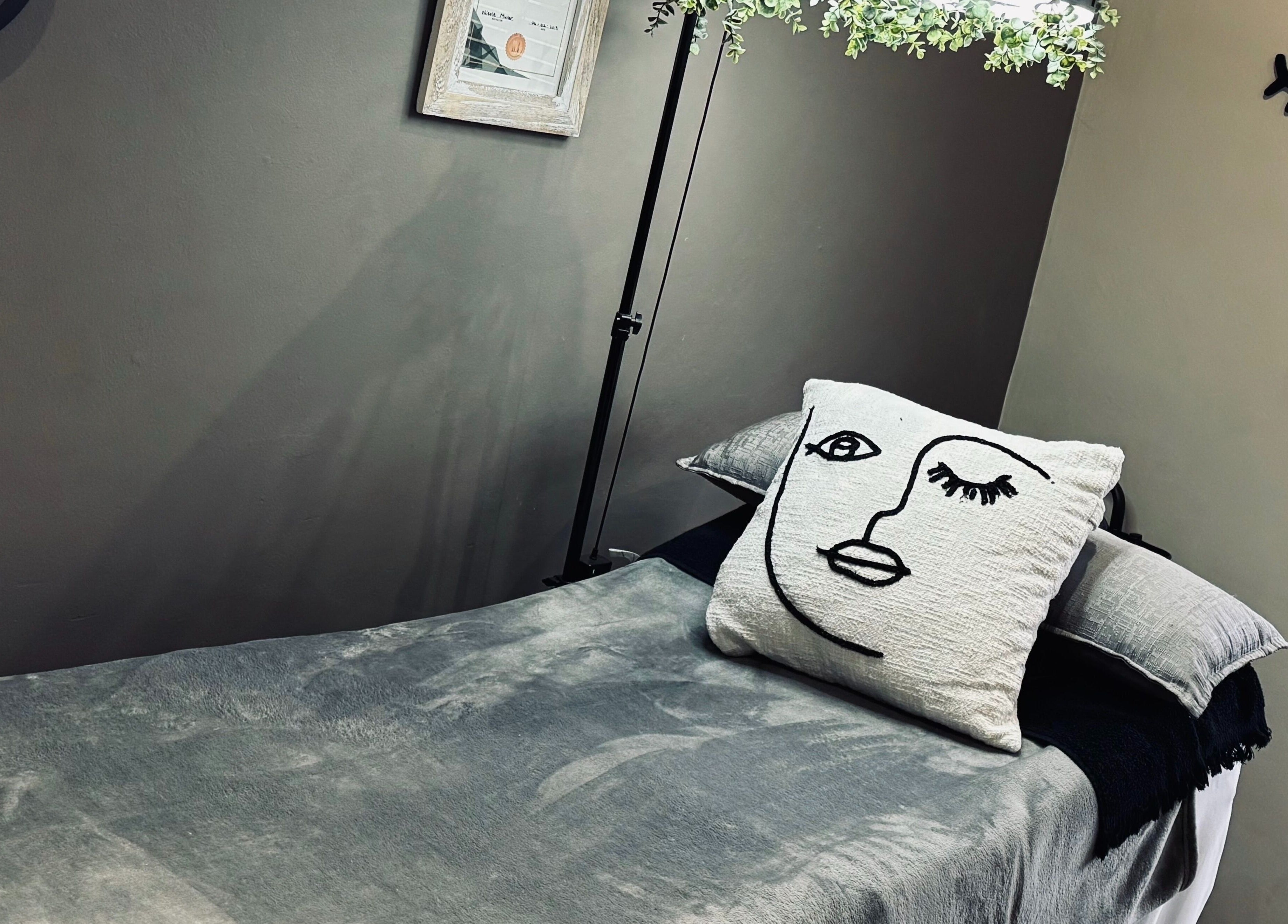 Cozy treatment bed at MS Lashes, Olifantsfontein, Gauteng, ZA with artistic pillow and serene decor.