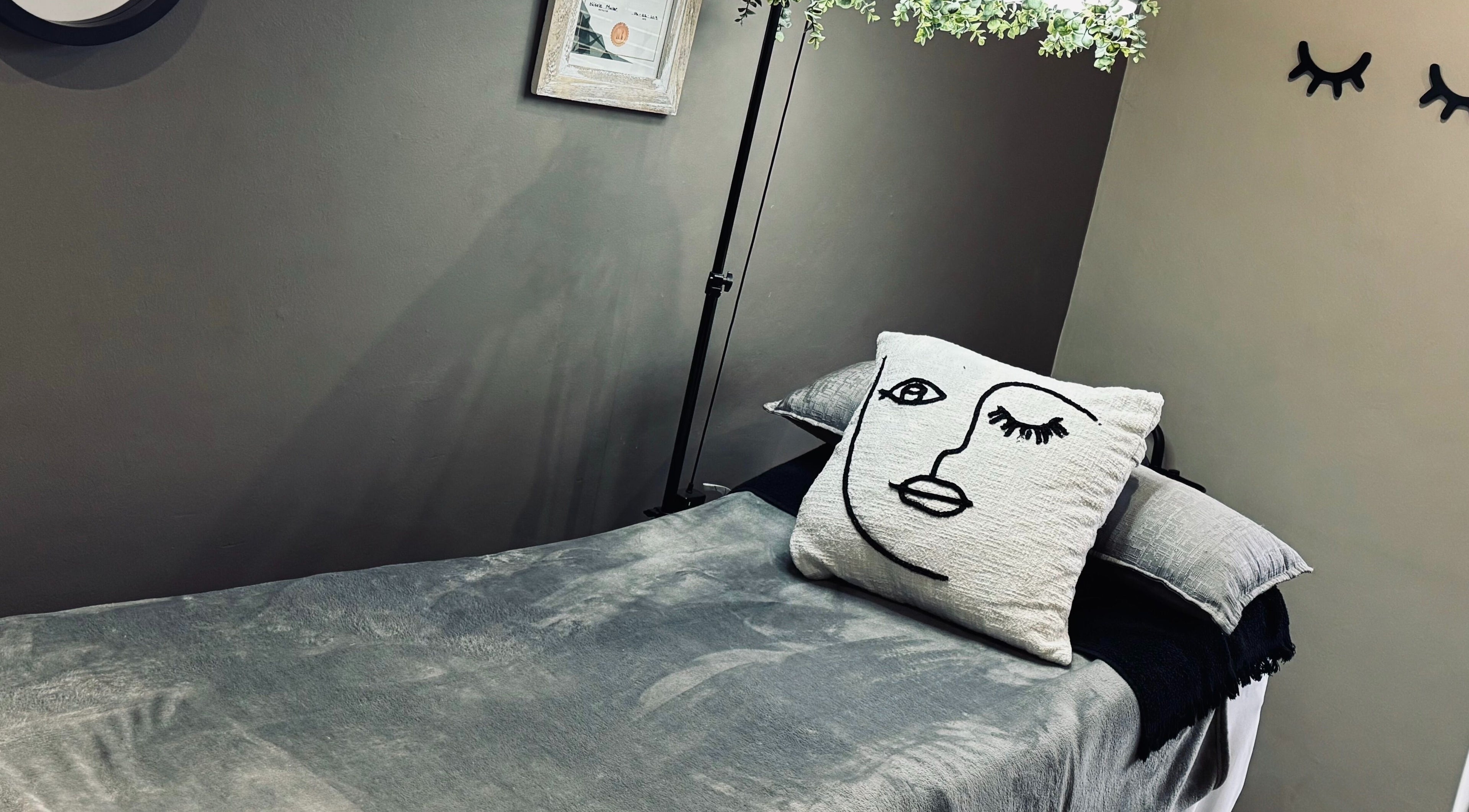 Cozy treatment bed at MS Lashes, Olifantsfontein, Gauteng, ZA with artistic pillow and serene decor.