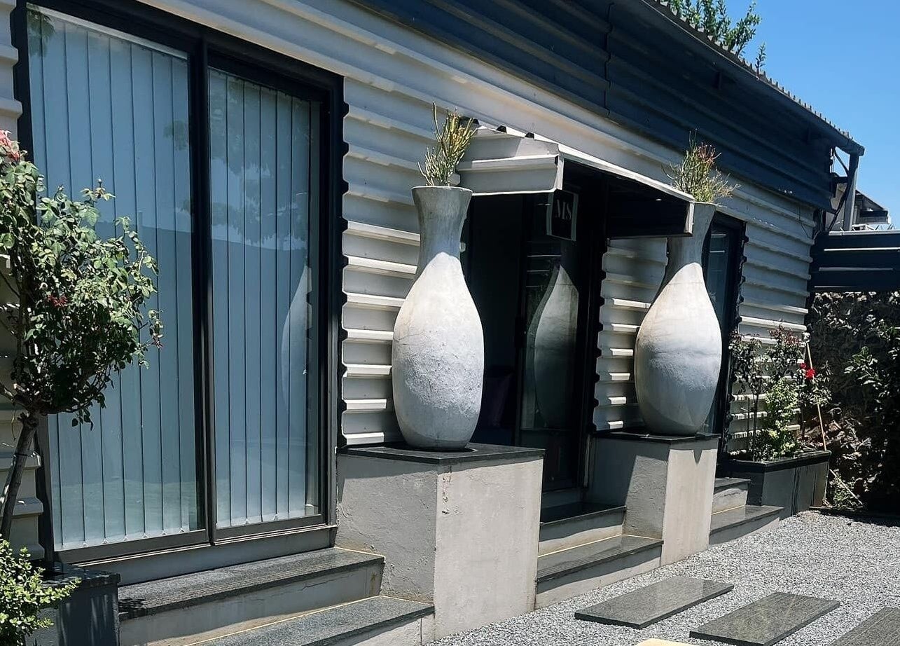 Stylish entrance of MS Lashes in Olifantsfontein, Gauteng, ZA, featuring modern design and large vases.