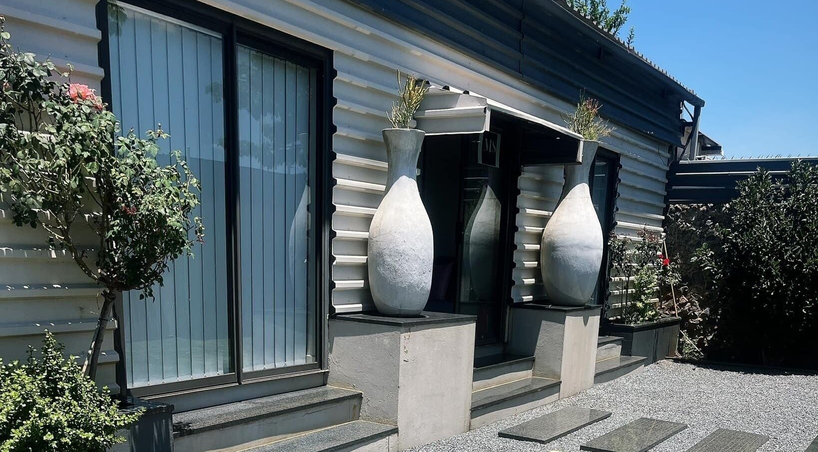 Stylish entrance of MS Lashes in Olifantsfontein, Gauteng, ZA, featuring modern design and large vases.