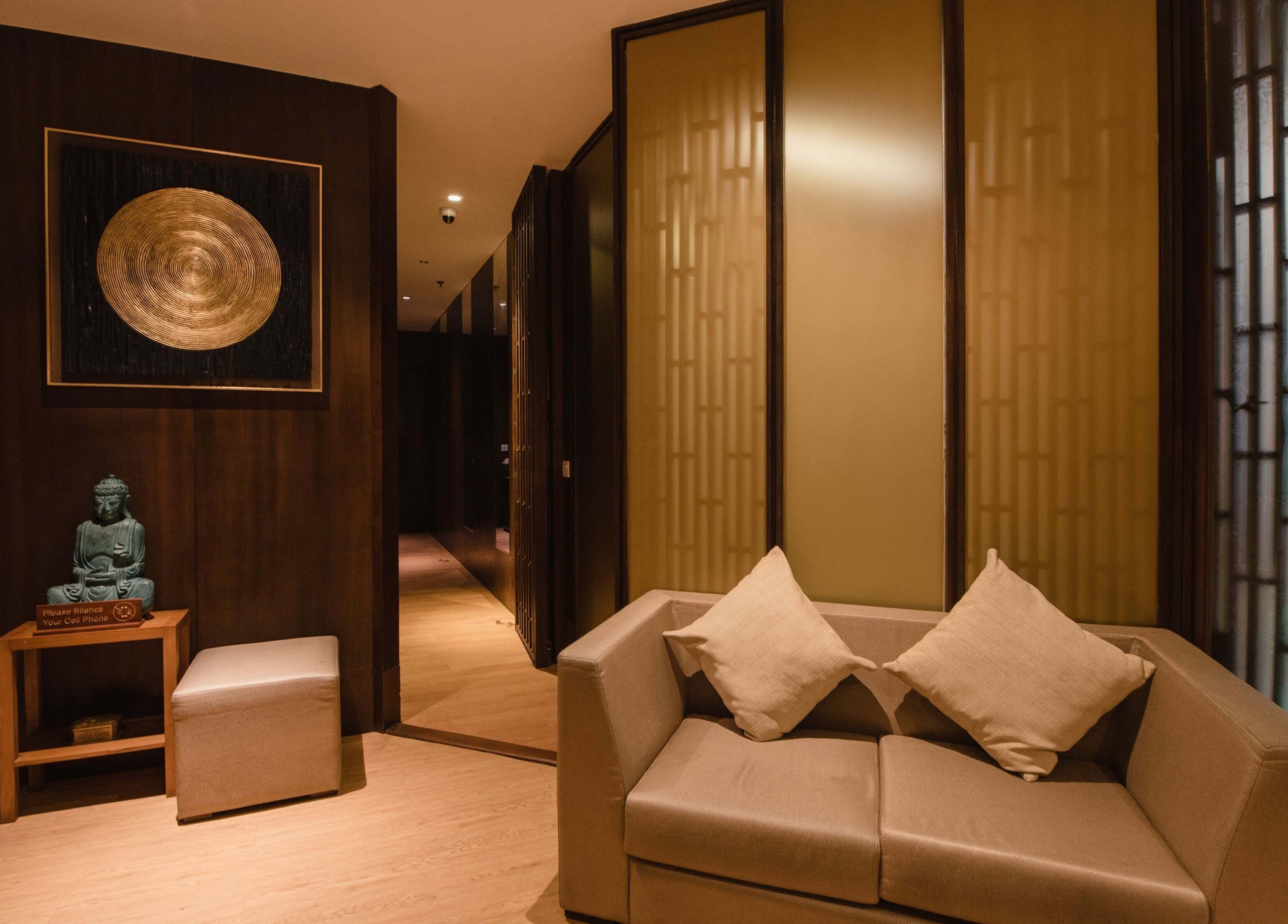 Tranquil lounge at Ambiente Reflexology at Sidewalk Jimbaran, Bali. Cozy sofa and zen decor enhance relaxation.