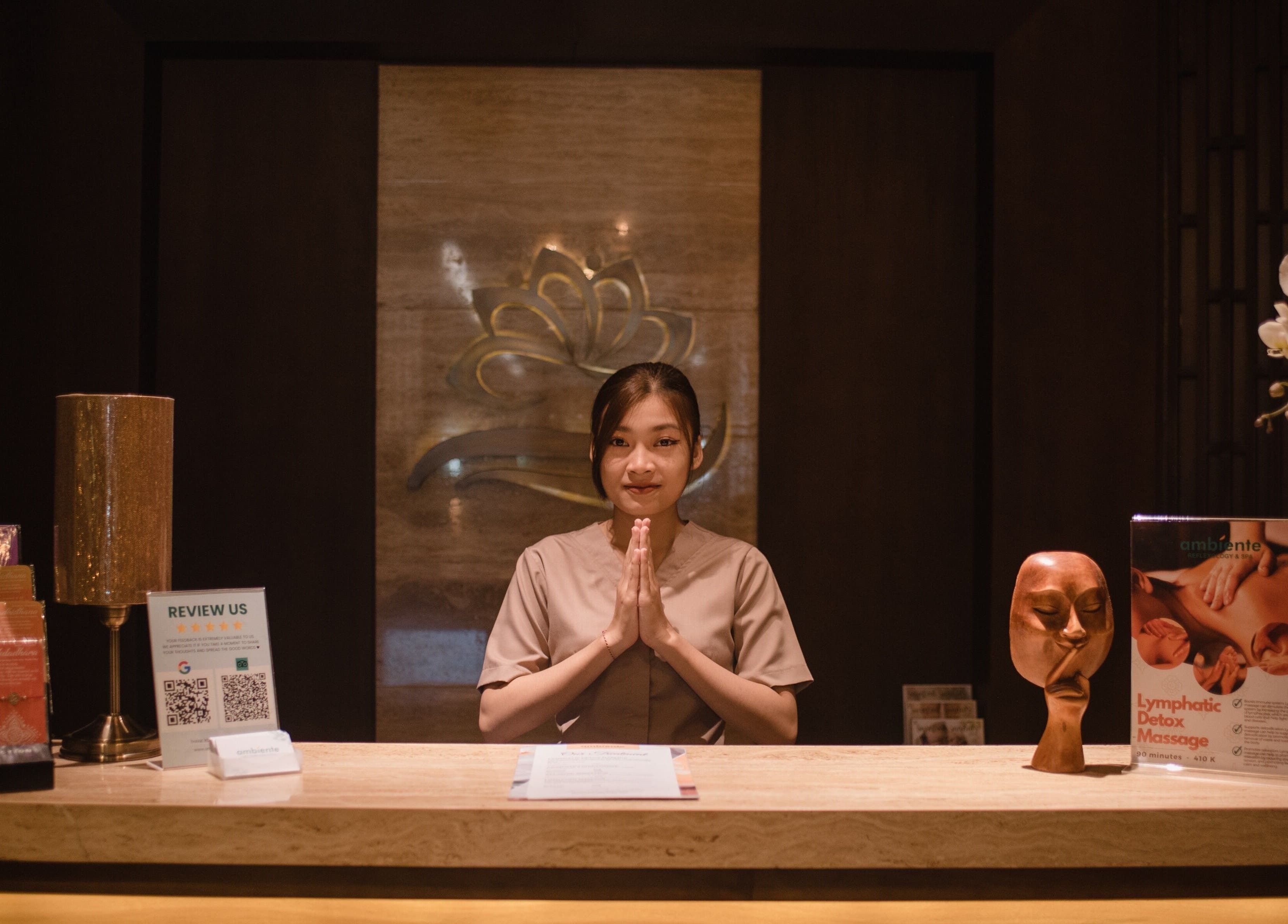 Receptionist at Ambiente Reflexology, Sidewalk Jimbaran, Bali offering a warm welcome in a serene space.