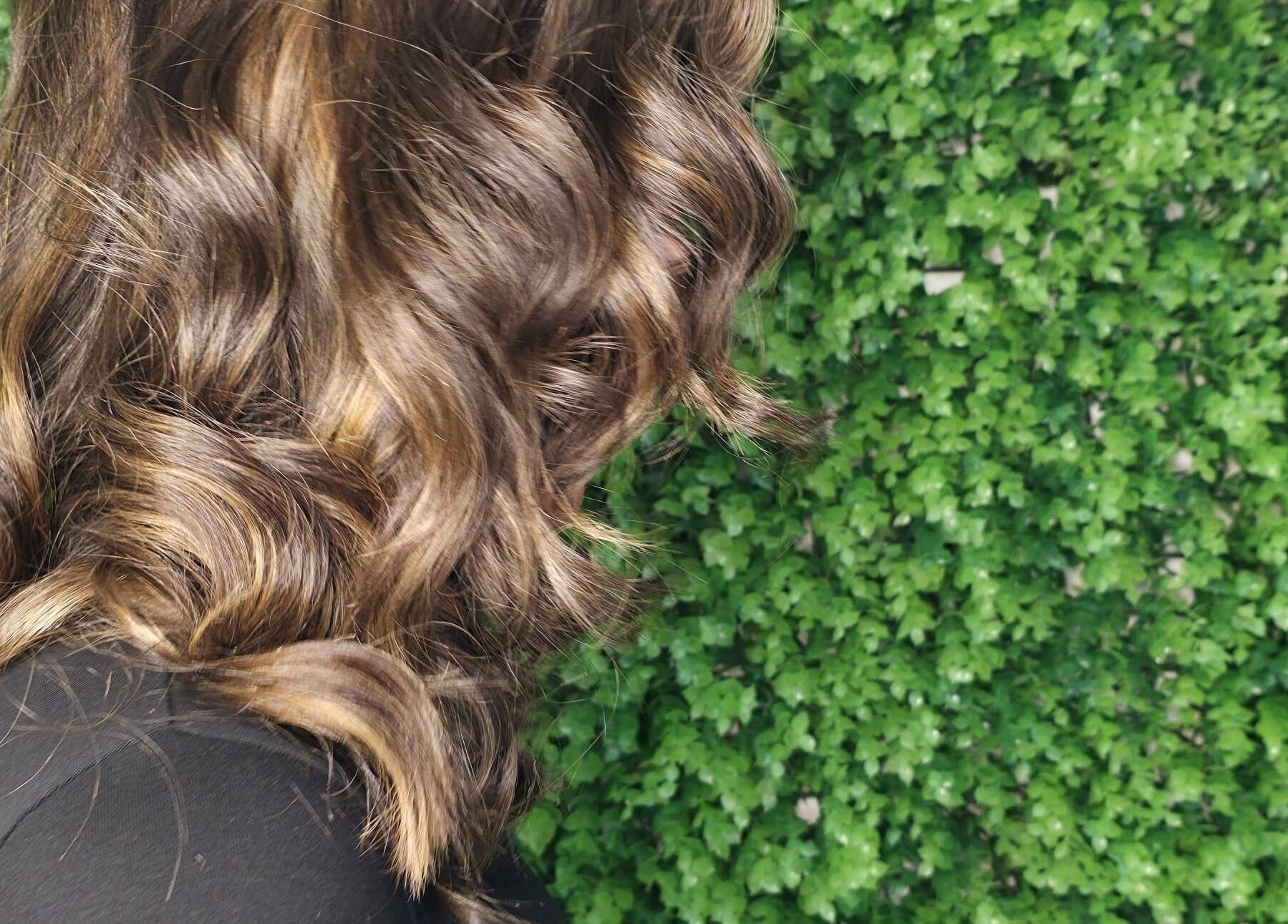 Luxurious wavy hair against lush greenery at L and B International, Sandton, Gauteng, ZA.