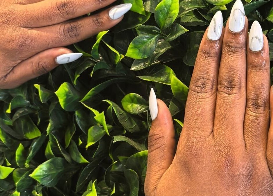 Beautiful white manicured nails against greenery at L and B International, Sandton, Gauteng, ZA.