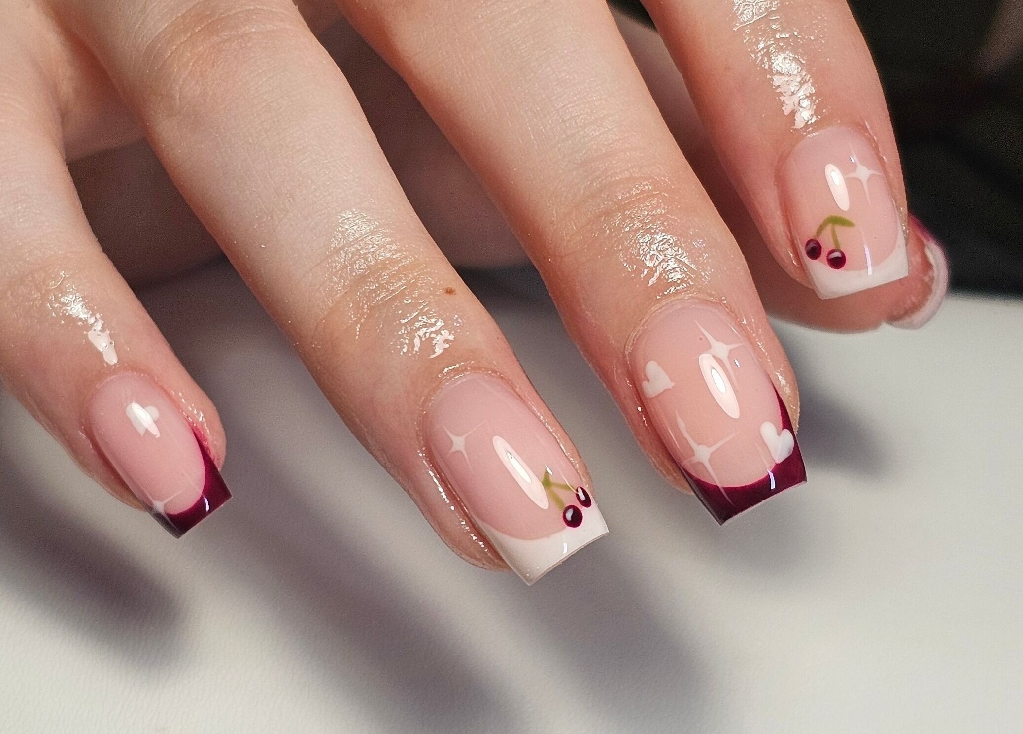 Stylish cherry-themed nail art by Nails by Alissia in Bournemouth, England, GB offering elegance and creativity.