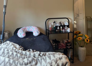 Relaxing setup at Paulina Kozyra Eyelash&Eyebrow, Loanhead, Scotland, GB with treatment bed and vibrant sunflowers.