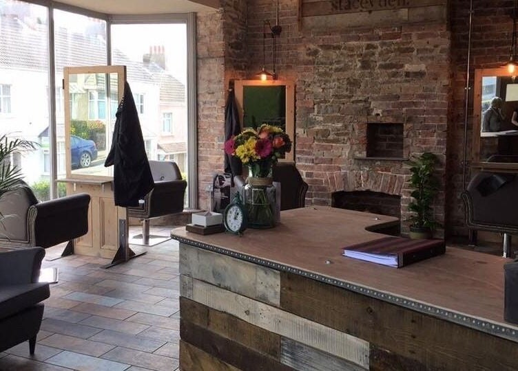 Cozy interior of Stacey Yuen Aveda Brynmill with brick walls and modern seating in Brynmill, Wales, GB.