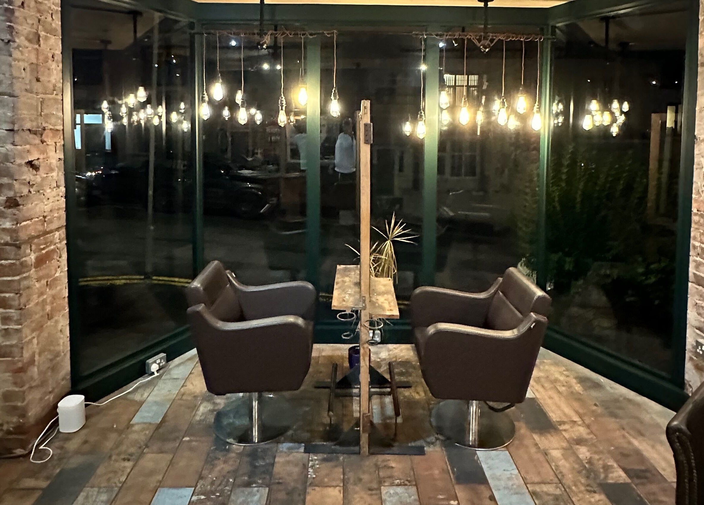 Cozy seating area at Stacey Yuen Aveda Brynmill, Brynmill, Wales, GB with warm lighting and rustic decor.