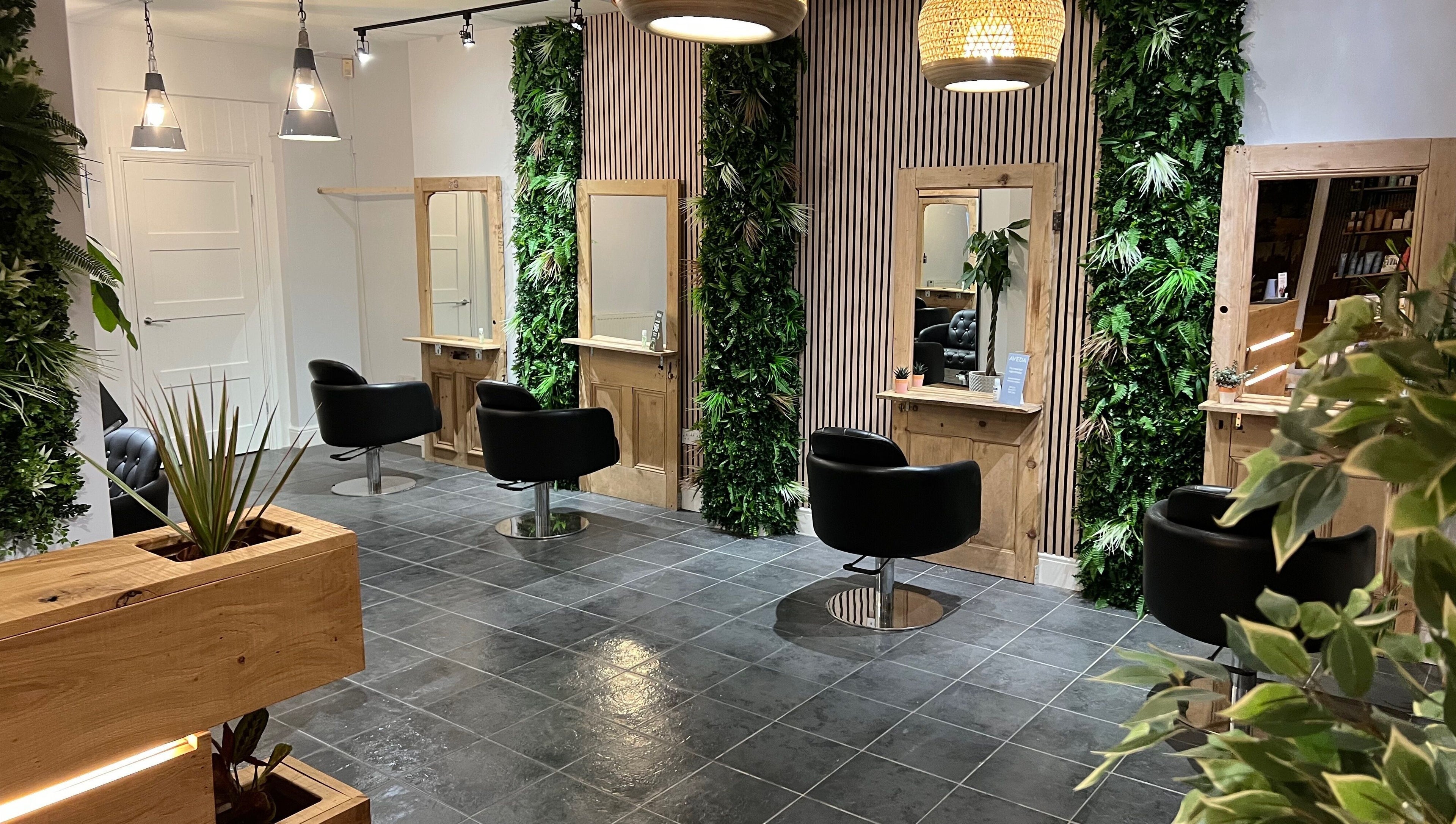 Stylish salon at Stacey Yuen Aveda Mumbles, Swansea, Wales, GB with modern decor and lush greenery.