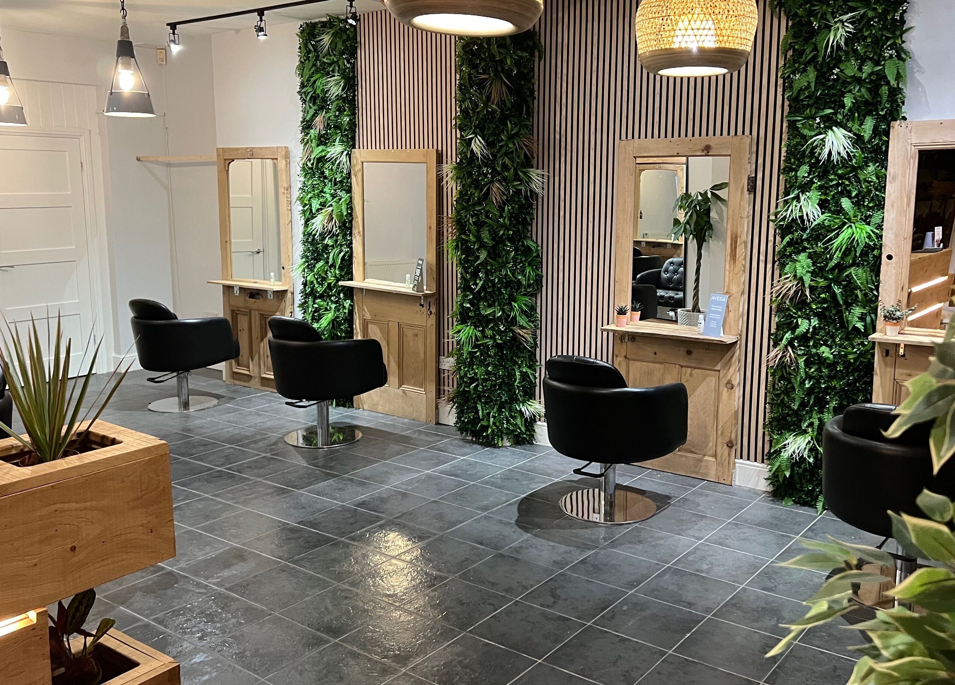 Stylish salon at Stacey Yuen Aveda Mumbles, Swansea, Wales, GB with modern decor and lush greenery.