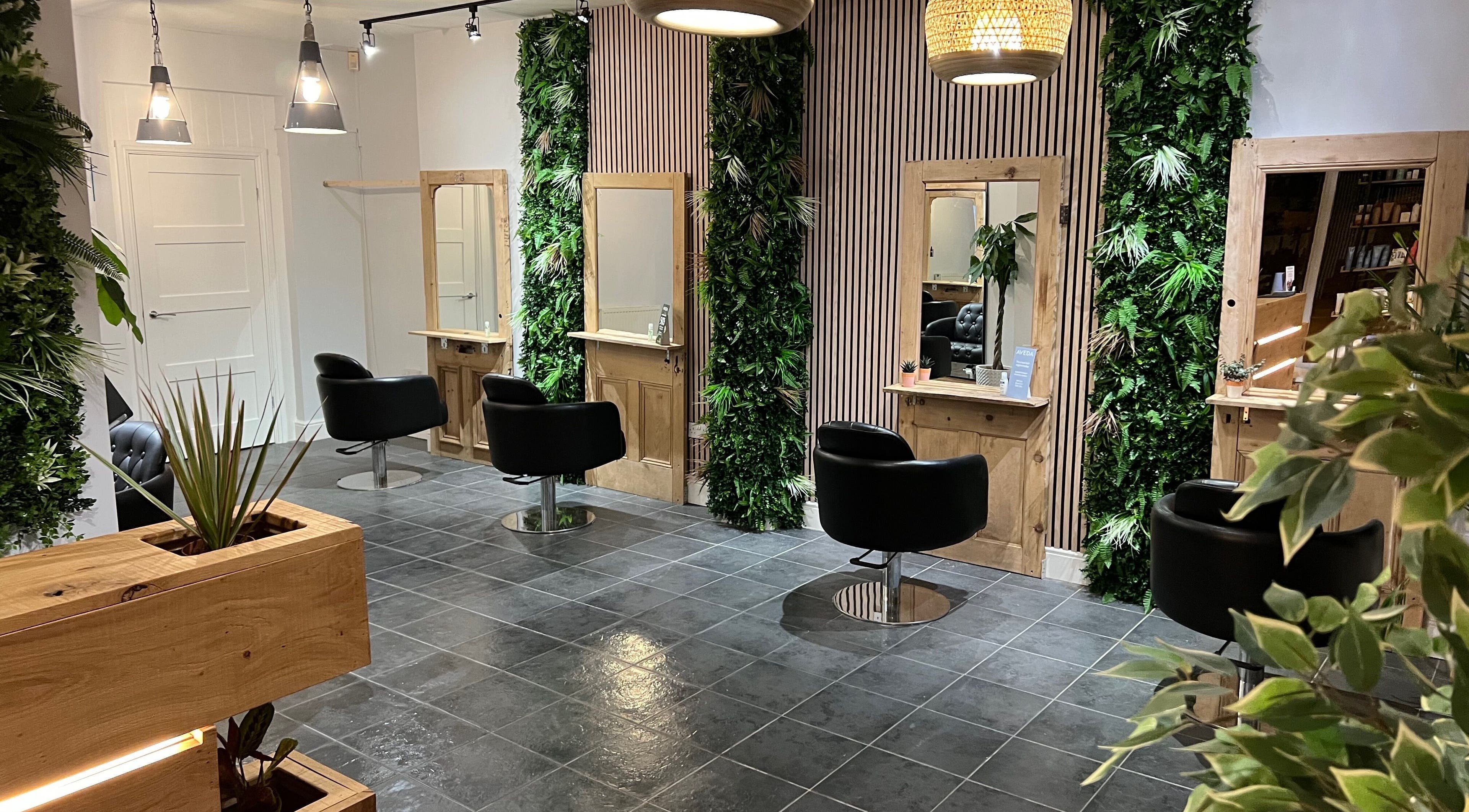 Stylish salon at Stacey Yuen Aveda Mumbles, Swansea, Wales, GB with modern decor and lush greenery.