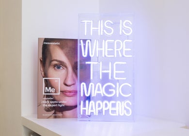 Neon sign 'This is where the magic happens' at Oxa Beauty, London, England, GB. Bright, inviting interior.