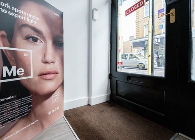 Poster showcasing skincare at Oxa Beauty entrance, London, England, GB.