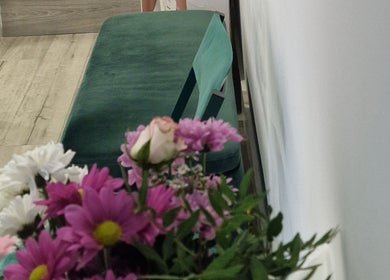 Floral decor beside a green velvet bench at Oxa Beauty, London, England, GB.