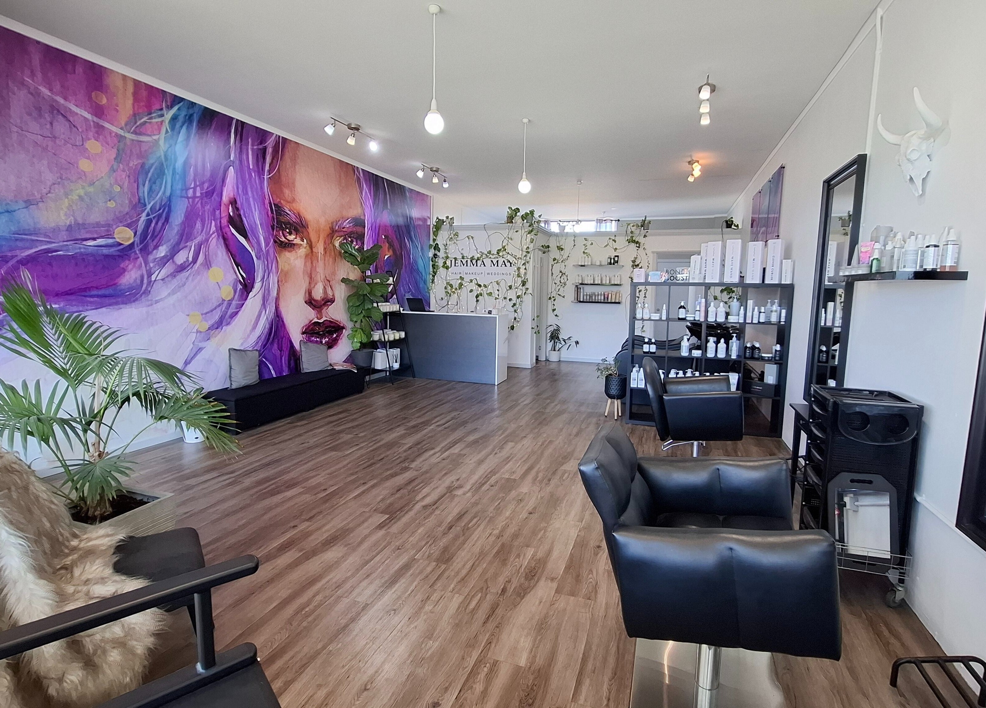 Interior of Jemma May in Albany, Western Australia, AU, featuring vibrant wall art and modern salon decor.