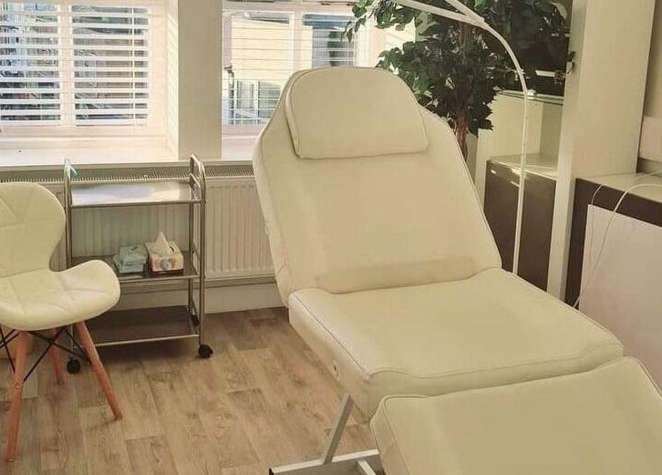 Luxury treatment room at The Little Wren, Caernarfon, Wales with a comfortable white bed and chair.