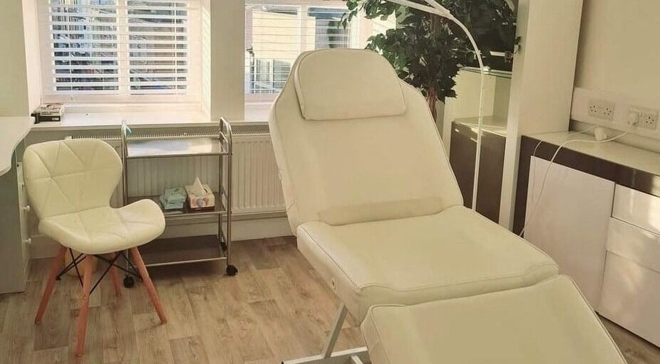 Luxury treatment room at The Little Wren, Caernarfon, Wales with a comfortable white bed and chair.