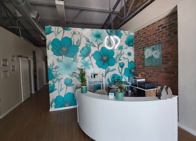Reception area of Azura Health and Beauty in Cape Town, Western Cape, ZA with floral wall art and modern decor.