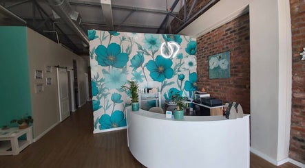 Reception area of Azura Health and Beauty in Cape Town, Western Cape, ZA with floral wall art and modern decor.